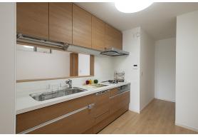 手元から足元までがすべてスライド式で収納力抜群のシステムキッチン。３口コンロ（無水両面焼きグリル）・食器洗い乾燥機・オールインワン浄水栓付きです。※物件によりカラーや設置イメージが異なる場合があります。