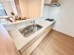 手元から足元までがすべてスライド式で収納力抜群のシステムキッチン。３口コンロ（無水両面焼きグリル）・食器洗い乾燥機・オールインワン浄水栓付きです。