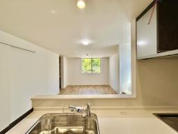 キッチンから見たリビングダイニング ご家族の様子を見守りながらお料理ができる対面式キッチン。自然と家族が集まる憩いの空間です。　