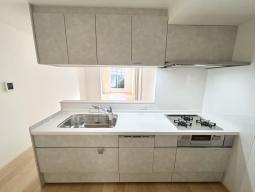 手元から足元までがすべてスライド式で収納力抜群のシステムキッチン。３口コンロ（無水両面焼きグリル）・食器洗い乾燥機・オールインワン浄水栓付きです。