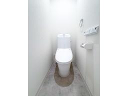 白を基調とした明るいお手洗い。フチレス形状で汚れがたまりにくく、水アカや汚れが付きにくい設計。清掃性や快適性に優れた一体型シャワートイレ（LIXIL）は清潔でクリーンな空間を実現します。