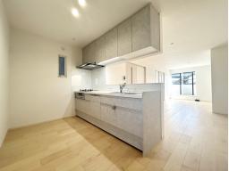 手元から足元までがすべてスライド式で収納力抜群のシステムキッチン。３口コンロ（無水両面焼きグリル）・食器洗い乾燥機・オールインワン浄水栓付きです。