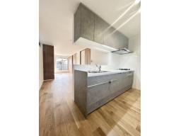 手元から足元までがすべてスライド式で収納力抜群のシステムキッチン。３口コンロ（無水両面焼きグリル）・食器洗い乾燥機・オールインワン浄水栓付きです。