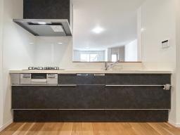 【キッチンイメージ】夕食後の片付けは食器洗い乾燥機にお任せ。家族でくつろぐ時間が自然と増えるキッチン。3口コンロとオールインワン浄水栓付。※掲載の写真は当社施工事例であり、本物件のものではありません。