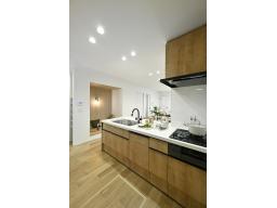 【同分譲地・施工事例】キッチンスペース：料理中も家族の気配を感じられる、開放感たっぷりのフラット対面キッチン。