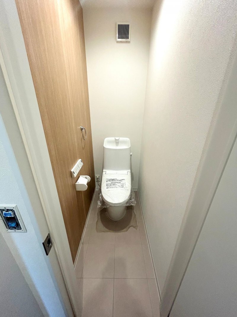 【トイレ】アクセントクロスは温かみのある木目調のデザインを採用。落ち着いた雰囲気を演出します。