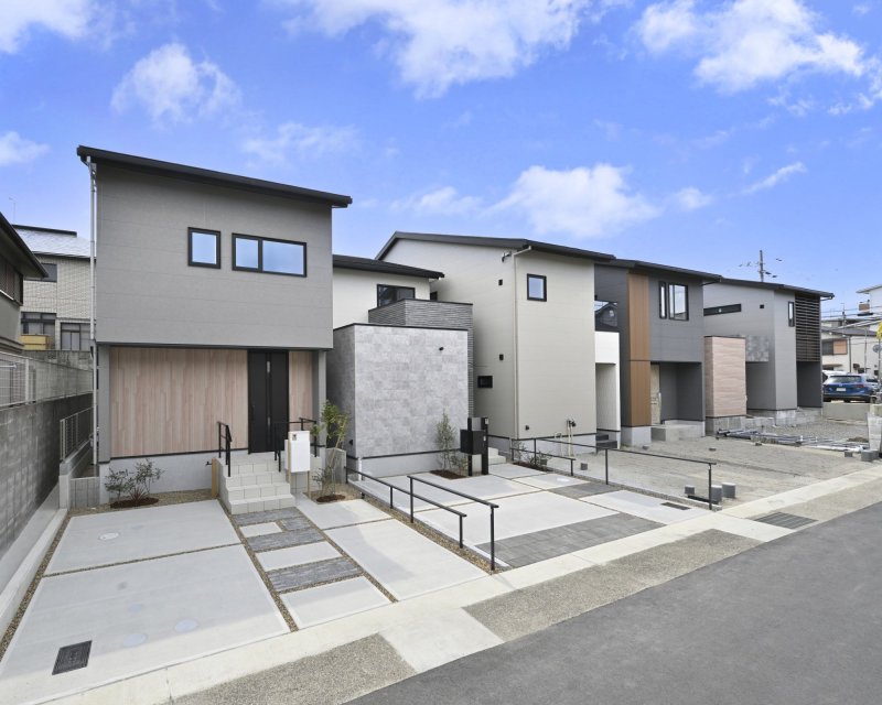 【街並み外観】手前より1号地・2号地（ご成約済）。本物件は左から5番目に位置する、グレーの石目調に、温かみのある木目調のアクセントが映えるデザインの邸宅です。