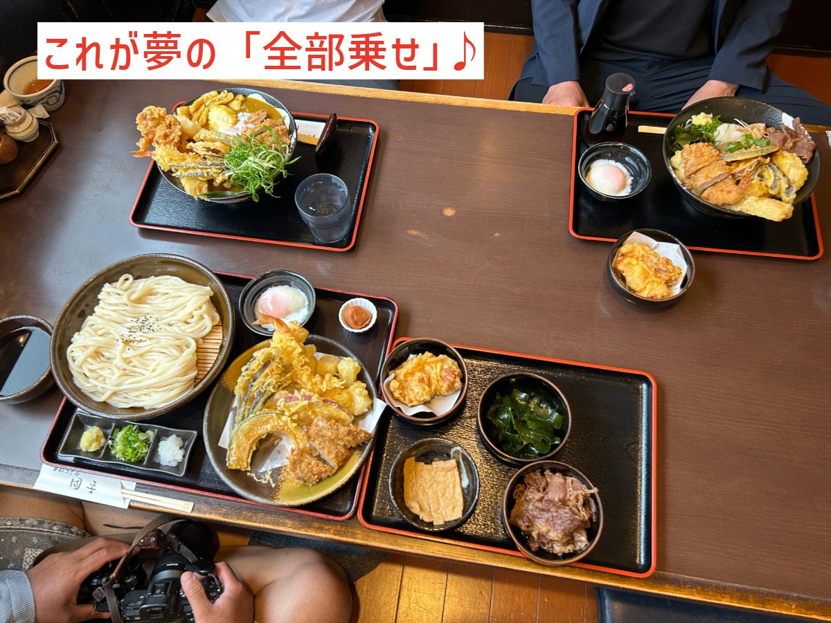 トッピングを全部乗せしたぶっかけうどん・生醤油うどん・鶏天カレーうどんの3種の丼が並ぶテーブル全景